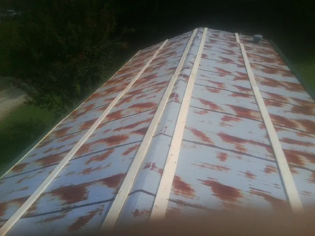 Rusted metal roof panels with new wood purlins before replacement — Storm Damage Roof Repair in Reading by Roofing Brothers